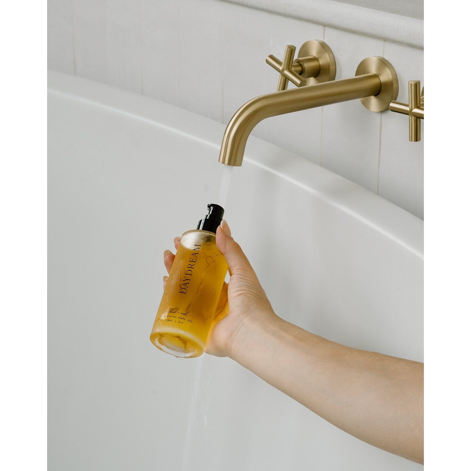Lifestyle photo showing DAYDREAM all-natural body oil in use - Orchid + Ash