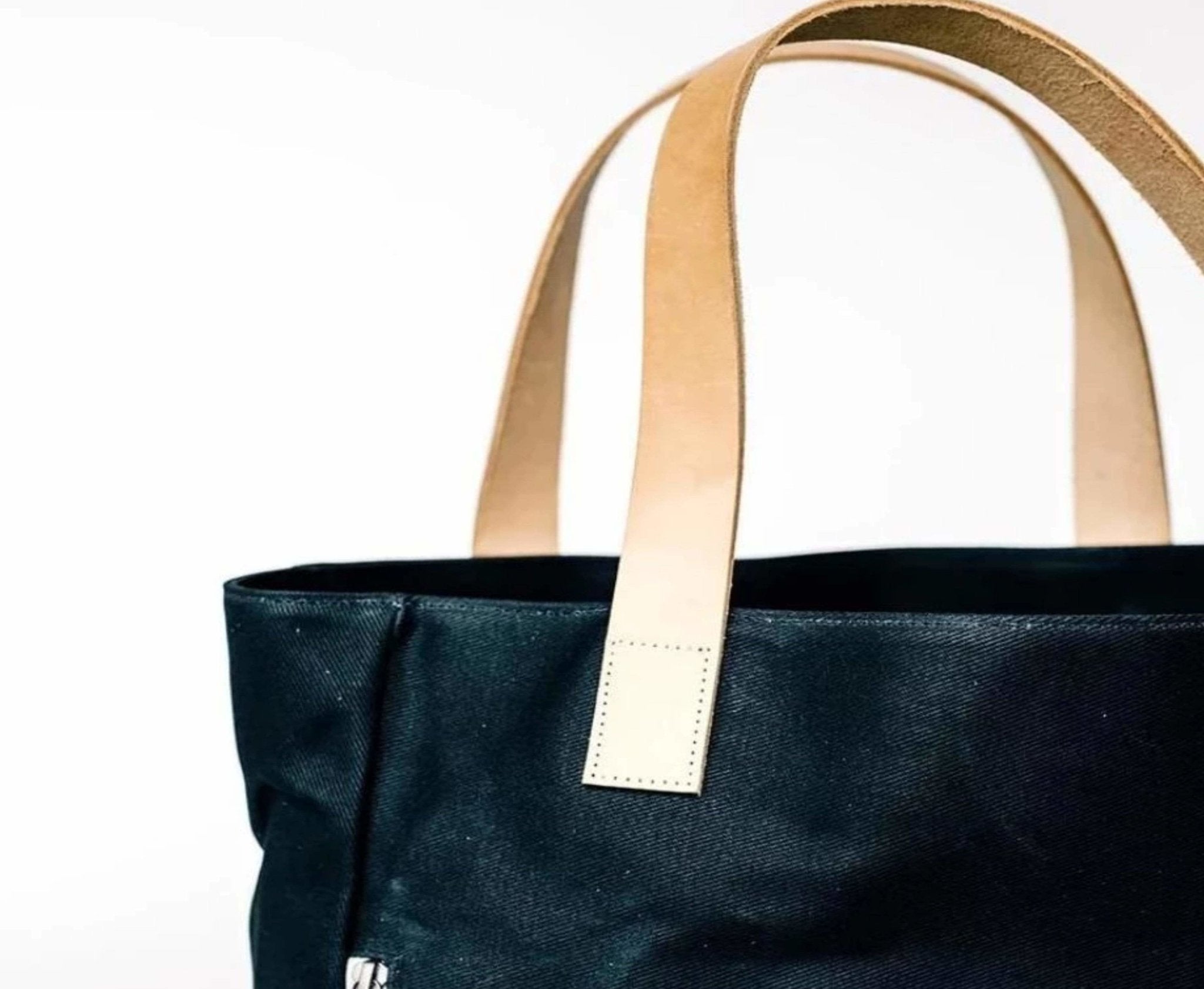 Lifestyle photo showing Black Wax Canvas Everyday Bag - The Classic in use - notebooks & honey
