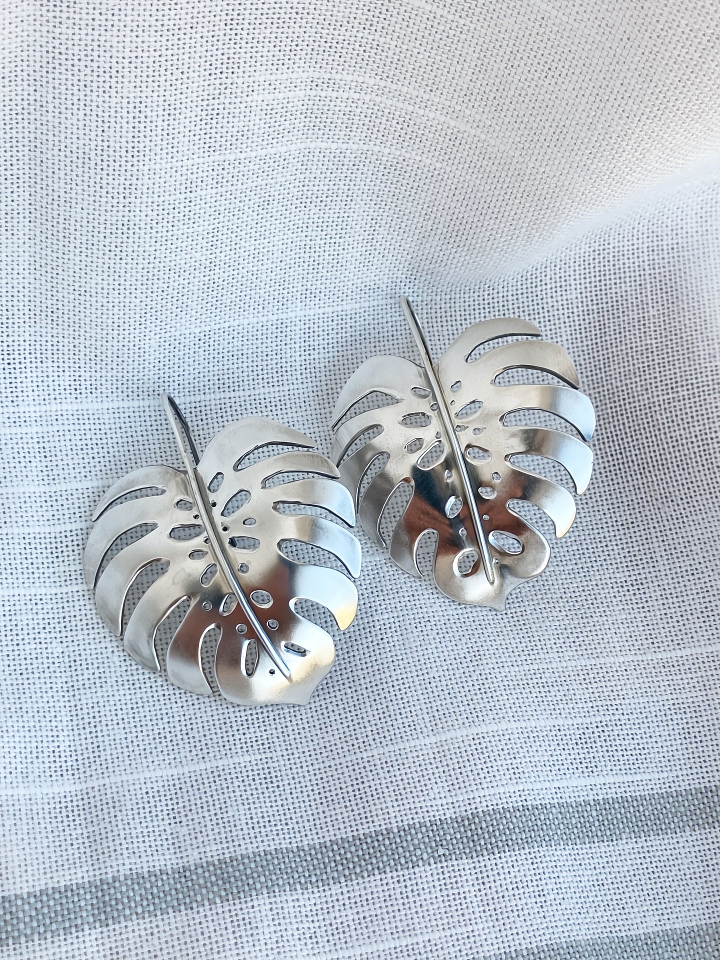Lifestyle photo showing Monstera Earrings in Sterling Silver - Large in use - Alison Morse