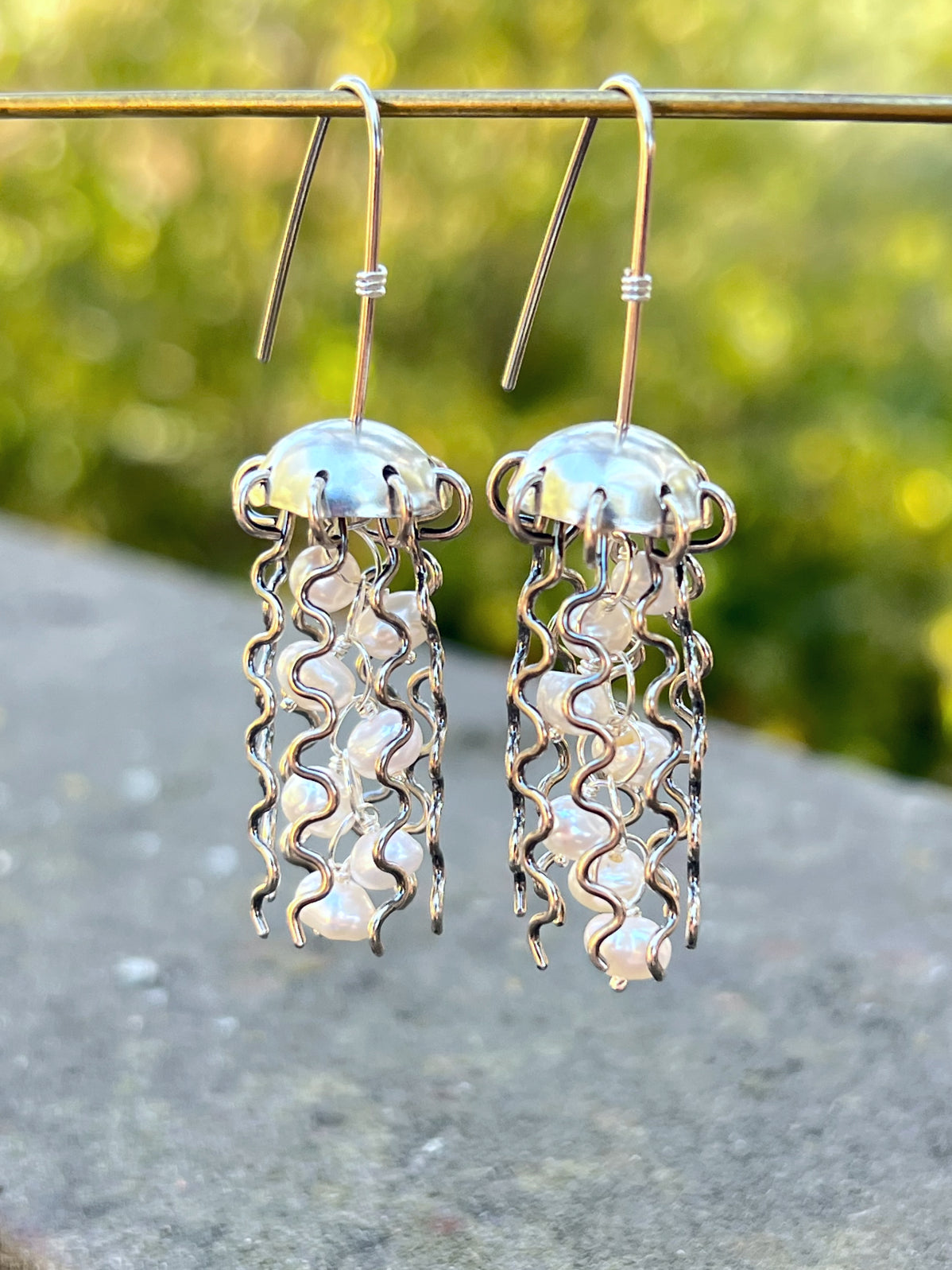 Lifestyle photo showing Sterling Silver Jellyfish Earrings with White Pearls in use - Alison Morse